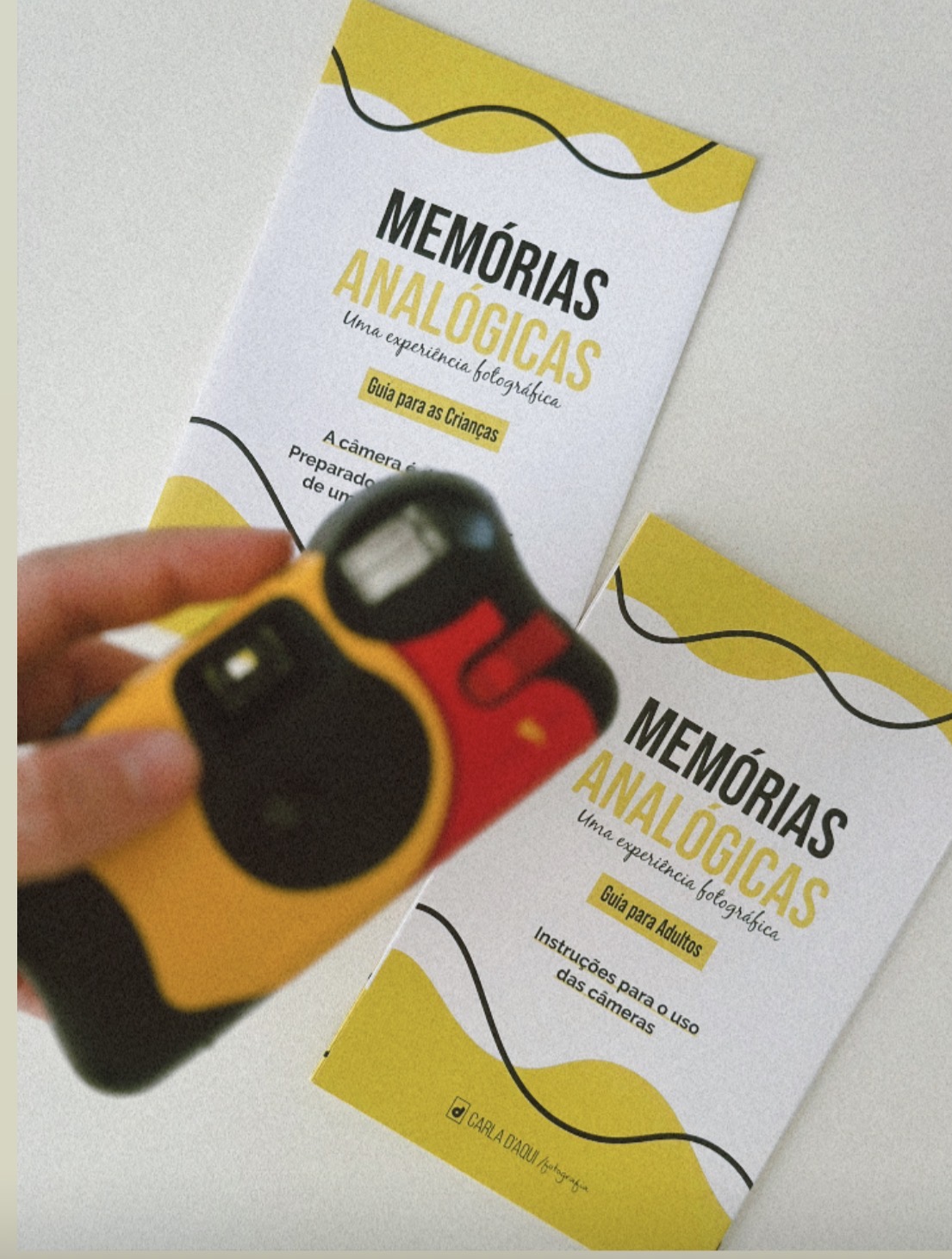 Câmera analógica amarela sobre os guias impressos para crianças e adultos